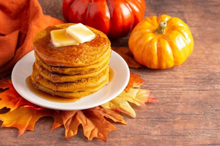 pumpkin pancakes on a table with leaves around them