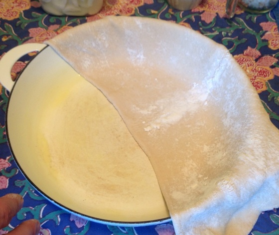 adding the timpano crust to the enameled cooking pan