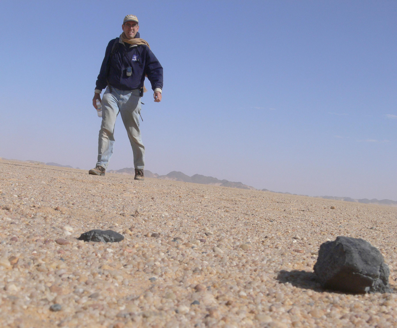 man walking in the desert and finding a meteorite
