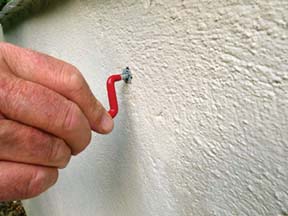 hanging a red hook on a cement wall