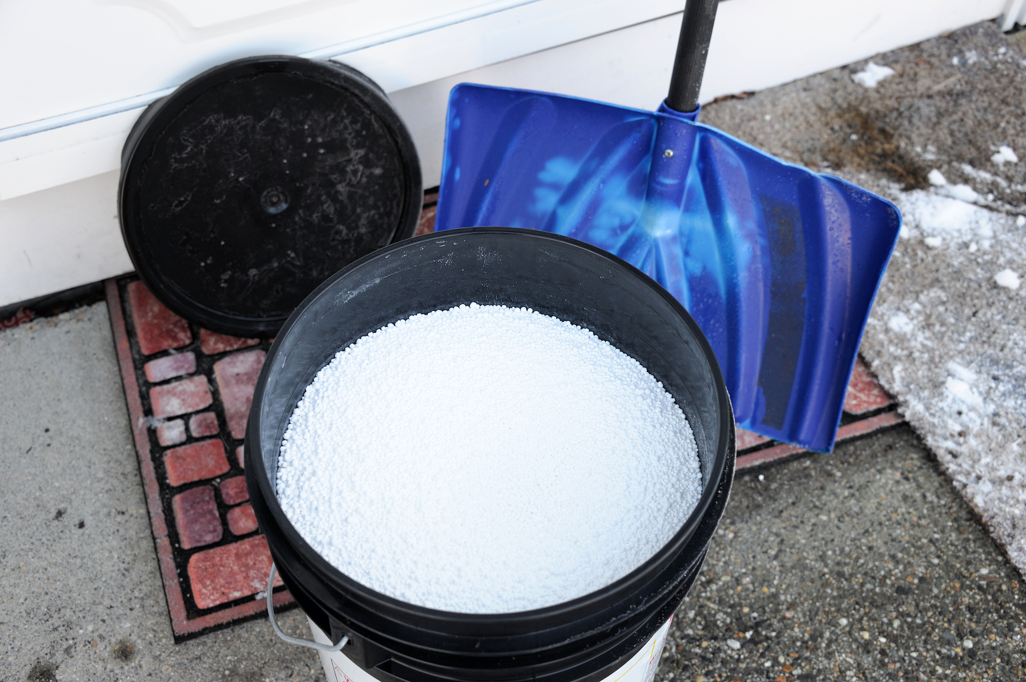 rock salt in a bucket for deicing with a snow shovel