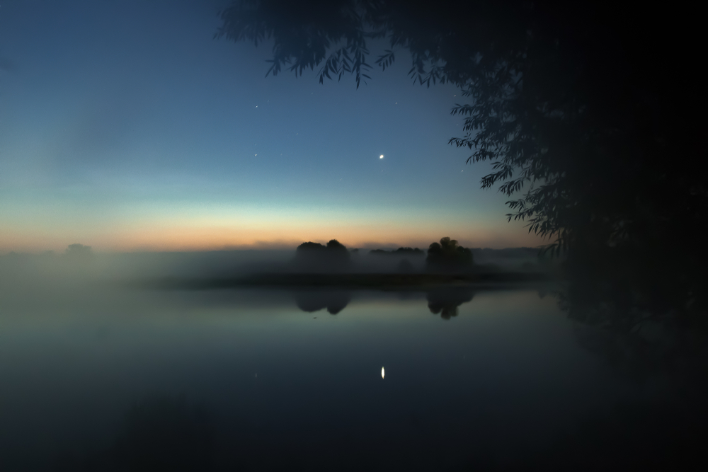 Astrophotography - the planet Venus is reflected in the water by a foggy morning