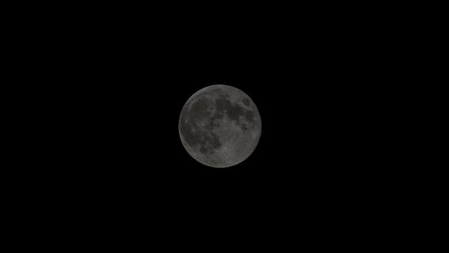 The near side of the moon at night as seen from earth with a dark background