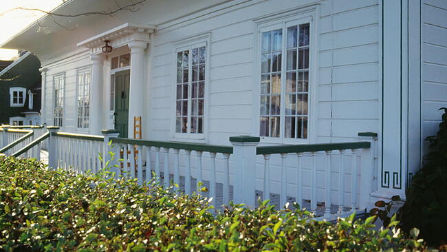the front of white house with green trim