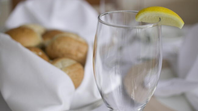 Dinner Glass on a dining room table with a lemon wedge