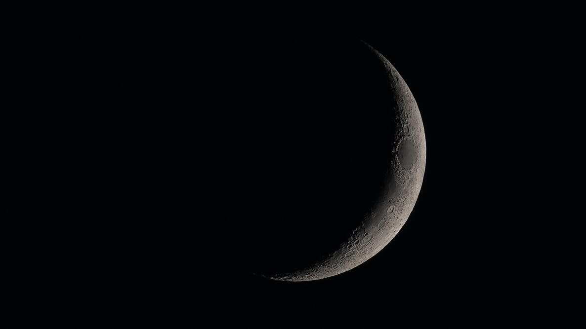 detailled new moon on dark sky; this serene and mystical image is perfect for illustrating astronomy, lunar cycles, or nighttime tranquility