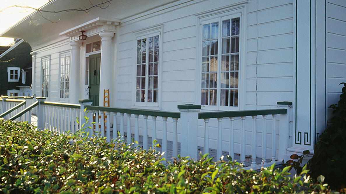 the front of white house with green trim