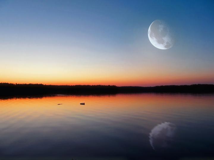 full moon at sunset over a lake