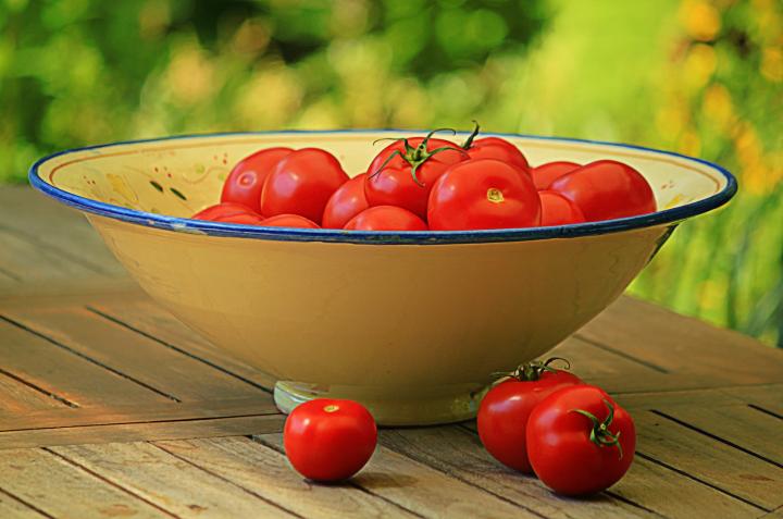 tomatoes in a bowl on an outdoor table