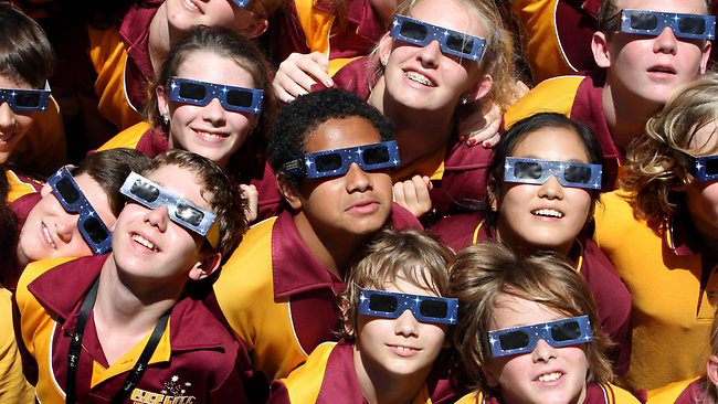 Kids watching solar eclipse with eclipse glasses