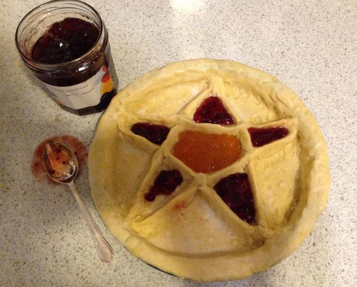 Ephiphany tart with a star shape in its top crust, shown with a pot of jam and a spoon